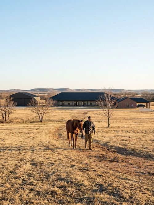 A male resident walks alongside a horse while participating in a restorative equine therapy session on the campus.