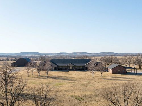 A distant scenic shot of the expansive men's addiction treatment center campus reveals rolling hills and serene nature.