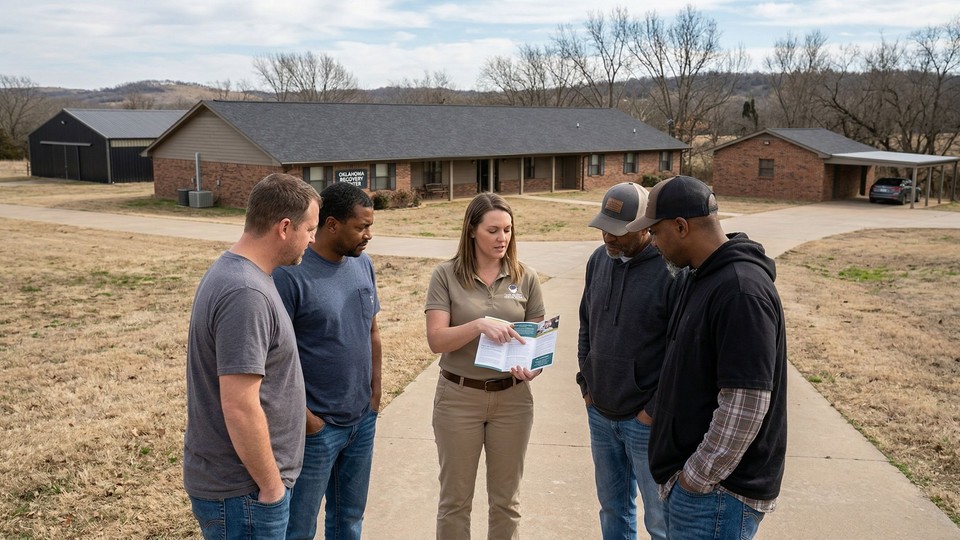 A group of men listens intently to a staff member during an educational off-campus event organized by the rehab.